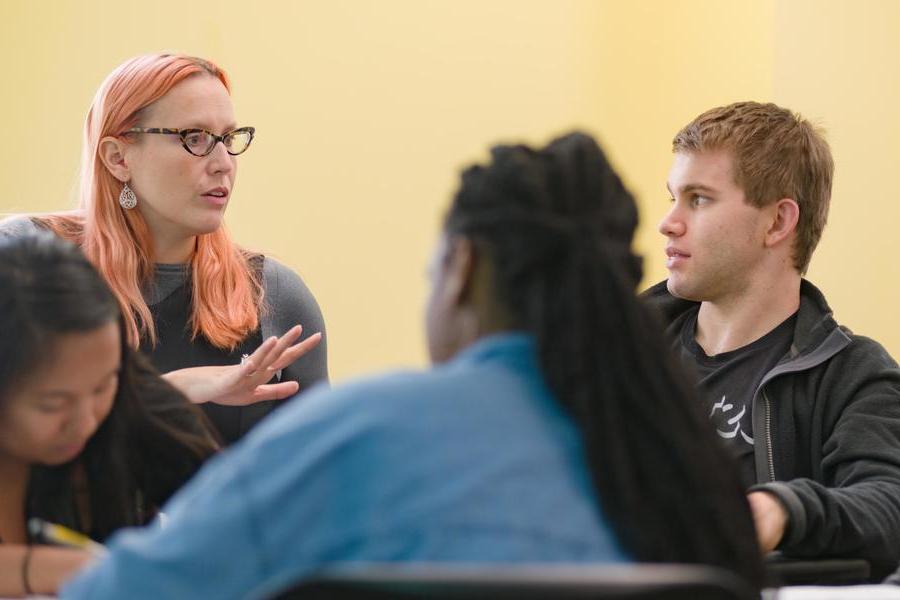 Post-baccalaureate program director instructing male and female students in class.